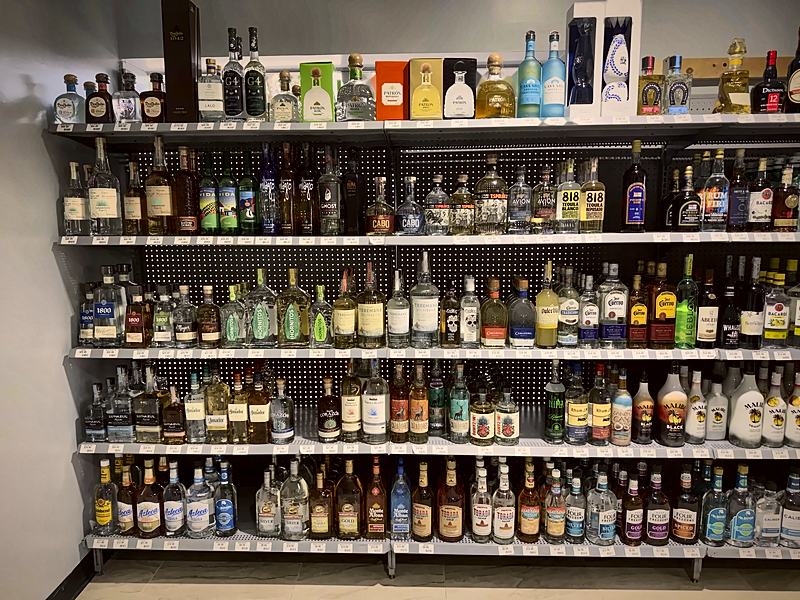 Wall of spirits shelving stocked with a wide mix of bottles