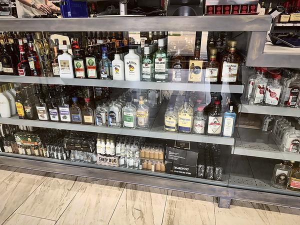 Glass counter case with an assortment of bottles