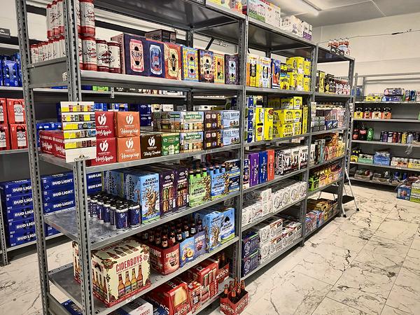 Rows of beer shelving with cases and six-packs